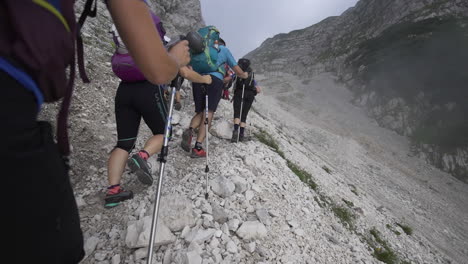 Triglav-looms-ahead-as-hikers-navigate-rocky-paths,-pushing-onward