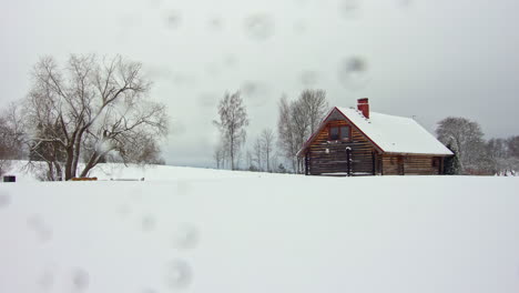 Weiße,-Verschneite-Landschaft,-Dreieckiges-Haus,-Bedeckt-Mit-Trockenen-Bäumen,-Landschaft-Im-Zeitraffer,-Wolken-Ziehen-Bei-Stürmischem-Wetter-Vorbei