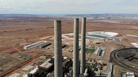 A-drone-shot-of-the-“Navajo-Generating-Station”,-a-massive-coal-fired-power-plant-and-industrial-complex-with-tall-stacks,-in-the-middle-of-the-desert-of-the-Navajo-Nation,-located-near-Page,-Arizona