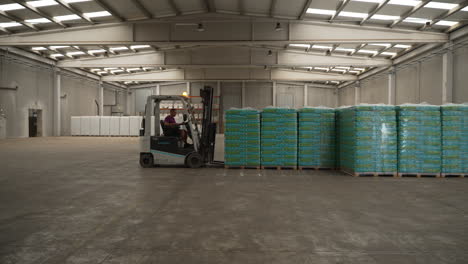 Warehouse-Forklift-Operator-Picking-Up-Pallet-Of-Fertile-Soil-Moving-To-Transport