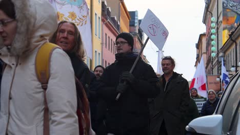 Mann-Mit-Covid-1984-Schild-Bei-Protestmarsch-Zum-Impfgesetz-In-Schweden,-Zeitlupe