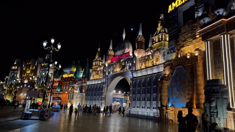 Dubai-Global-Village,-Europe-and-Americas-Pavilion-Gates-in-Lights-and-People