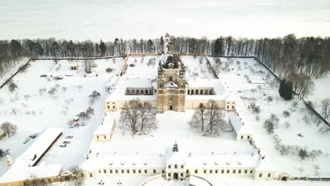 Aerial-view-of-the-Pazaislis-monastery-and-the-Church-of-the-Visitation-in-Kaunas,-Lithuania-in-winter,-snowy-landscape,-Italian-Baroque-architecture,-zooming-in