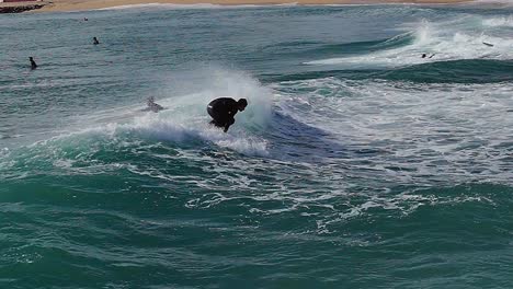 Slow-motion-:-young-male-surfer-surfing-the-wave-in-Barcelona,-Spain