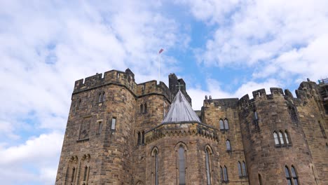 British-Flag-Waving-on-Top-of-Alnwick-Medieval-Castle,-England-UK,-Low-Angle-Slow-Motion