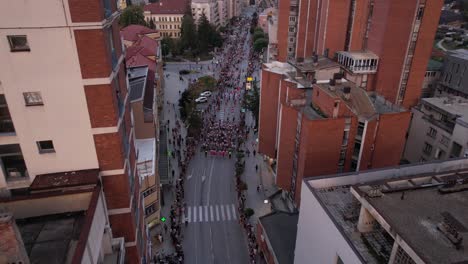 Vista-Aérea-De-La-Procesión-Del-Festival-De-Folclore-Infantil-Licidersko-Srce-En-La-Calle-Principal-De-Uzice,-Serbia