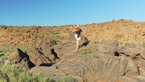 La-Madre-Lleva-Al-Bebé-En-Un-Portabebés-Mientras-Escala-Rocas-En-El-Parque-Nacional-Del-Teide,-Tenerife