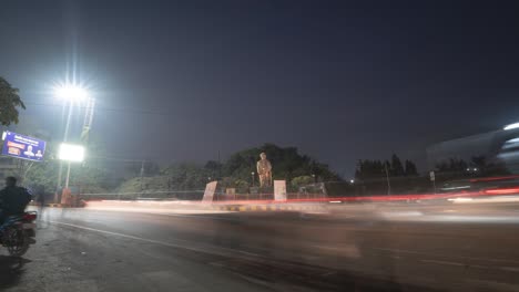 Night-Time-lapse-of-fast-moving-traffic-making-light-trails-on-road-square-in-India