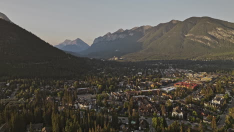 Banff-AB-Canada-Aerial-v21-flyover-residential-area-and-mountain-township-capturing-picturesque-townscape,-forested-valley-and-mountainous-landscape-at-sunrise---Shot-with-Mavic-3-Pro-Cine---July-2023
