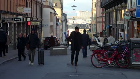 People-move-around-on-pedestrian-street-in-fall-in-Stockholm,-Sweden