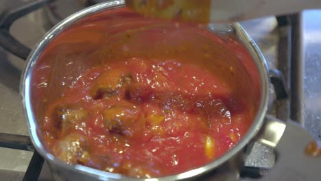 Primer-Plano-De-Albóndigas-En-Salsa-De-Tomate-Revueltas-Con-Una-Cuchara-De-Madera