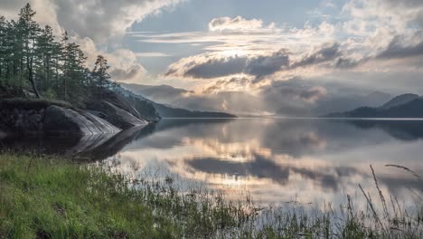 Las-Pesadas-Nubes-Iluminadas-Por-El-Sol-Poniente-Se-Reflejan-En-Las-Tranquilas-Aguas-Del-Lago.