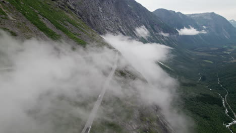 Luftaufnahme-Einer-Wolkenverhangenen-Haarnadelkurve-Im-Trollstigen-In-Norwegen,-Die-Sich-Die-Steile-Talseite-Hinunterschlängelt