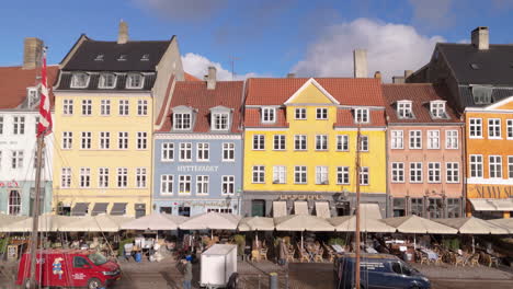Popular-Nyhavn-waterfront-with-historic-colorful-buildings-and-cafés,-aerial