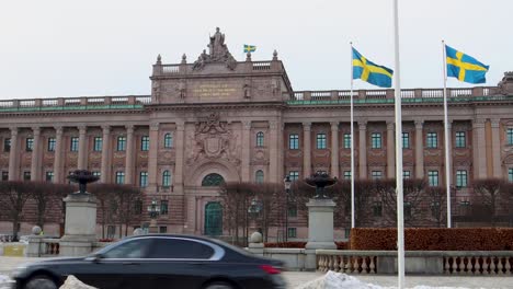 Cars-drive-by-Swedish-Parliament-building-in-Stockholm,-Sweden