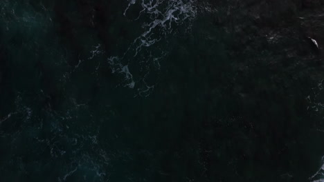 Luftaufnahme-Aus-Der-Vogelperspektive-Von-Großen-Und-Mächtigen-Wellen,-Die-Auf-Das-Durchscheinende-Meer-An-Der-Felsigen-Küste-Von-Hawaii-Stürzen