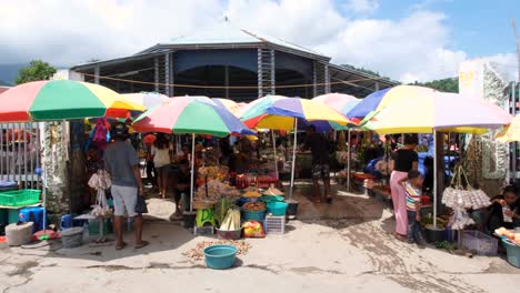 Menschen-Kaufen-Auf-Dem-Obst--Und-Gemüsemarkt-Von-Taibesi-Mit-Bunten-Sonnenschirmen-In-Der-Hauptstadt-Von-Osttimor,-Südostasien,-Lokal-Angebaute-Produkte-Ein