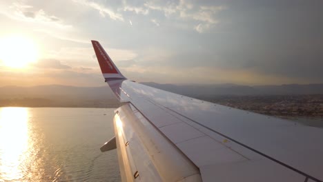 POV-of-wing-of-airplane-over-water-about-to-land-in-Nice,-France