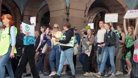 Protesters-march-at-environmental-rally-on-street-in-Stockholm,-static
