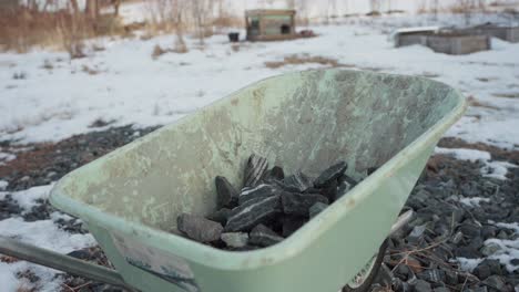 The-Man-is-Loading-Rocks-Into-the-Wheelbarrow-For-Use-in-Constructing-a-DIY-Hot-Tub---Timelapse