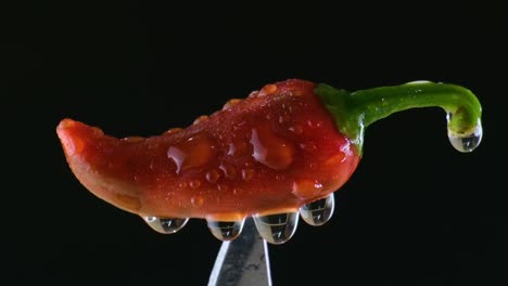 Water-getting-sprinkled-on-a-red-chilli-on-top-of-a-knife