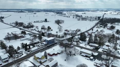 Vehicles-on-road-in-snowy-american-village-in-winter