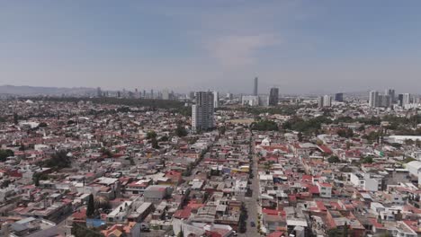 forward-aerial-view-reaching-a-building-near-park-of-Paseo-Bravo-in-Puebla
