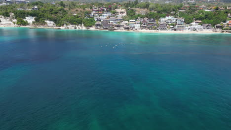 Manta-Rochen-Schwimmt-Im-Vordergrund,-Während-Surfer-Im-Hintergrund-Vor-Uluwatu-Bali-Indonesien-Schweben