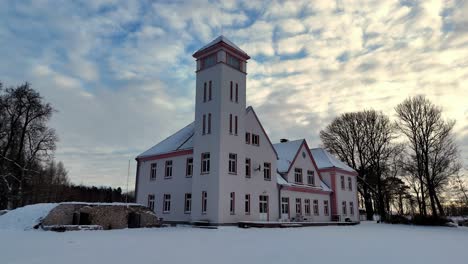 A-large-white-building-with-a-red-roof-and-a-clock-tower