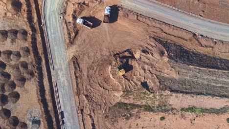 Yarrawonga,-Victoria,-Australia---8-March-2024:-Top-down-aerial-view-of-an-excavator-and-trucks-working-to-move-soil-at-a-new-stage-on-Silverwoods-Estate-at-Yarrawonga