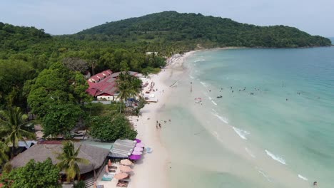 Vista-Aérea-De-Drones-En-Vietnam-Sobrevolando-La-Playa-De-La-Isla-Phu-Quoc-Sao,-Arena-Blanca,-Aguas-Cristalinas-De-Color-Azul-Turquesa,-Palmeras-Verdes-Y-Gente-Caminando-En-Un-Día-Soleado