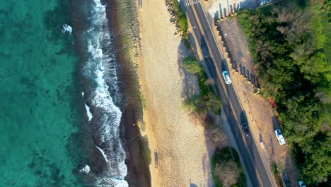 Pacific-ocean,-sandy-beach-and-Hawaii-road,-aerial-drone-view