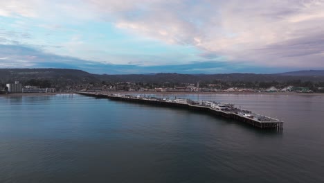 Aerial-drone-shot-flying-in-towards-santa-cruz,-California-over-the-ocean