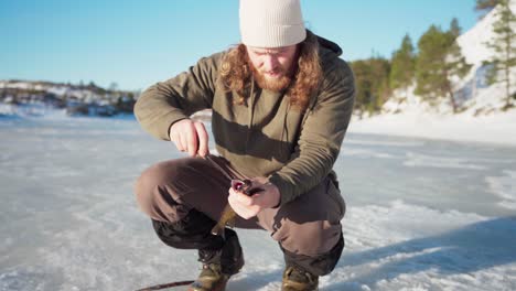 The-Man-is-Preparing-the-Fish-he-Caught-While-Ice-Fishing-in-Bessaker,-Trondelag-County,-Norway---Close-Up