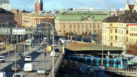 Car-and-subway-train-traffic-in-Stockholm-in-evening-sunlight,-static