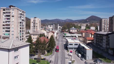 Trbovlje,-Slovenia,-Flying-Above-Main-Street-Traffic-by-Shops-and-Residential-Buildings
