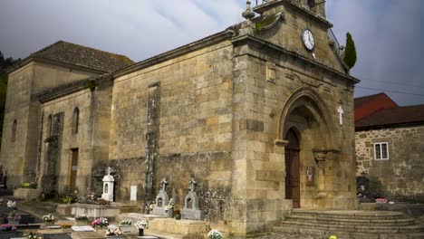 Side-angle-tilt-up-establishes-bell-tower-and-clock-at-front-of-Santa-Maria-de-Punxin-in-Ourense-Galicia-Spain