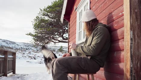 El-Hombre-Disfruta-De-Una-Bebida-Caliente-Con-Su-Perro-Cerca-En-La-Temporada-De-Invierno-En-Bessaker,-Condado-De-Trondelag,-Noruega---Toma-Estática