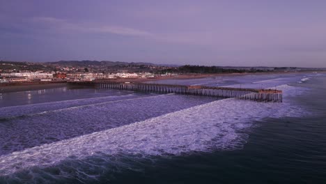 dramatic-drone-shot-flying-in-towards-the-pismo-beach-pier-during-sunset