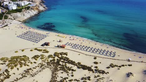 Drone-strafing-above-the-beachfront-of-the-Cala-Mesquida-resort,-a-secluded-tourist-getaway-situated-in-the-island-of-the-Mediterranean-island-of-Mallorca,-Spain