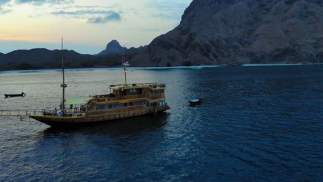 A-cruise-ship-anchored-off-the-coast-of-Padar-Island,-near-Komodo-in-Indonesia,-captured-from-a-drone-during-the-evening