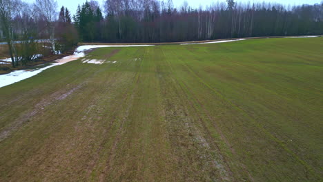 Snowy-fields-in-early-spring,-aerial-view-moody-grey-day