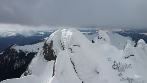 Schneebedeckter-Tiaile-Mari-Gipfel-In-Den-Ciucas-Bergen-Unter-Bewölktem-Himmel,-Weite-Aussicht