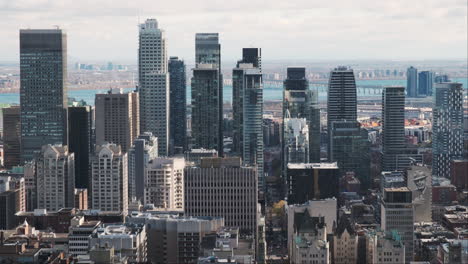 Blick-Auf-Die-Lebendige-Skyline-Der-Innenstadt-Von-Montreal,-Hoch-Aufragende-Wolkenkratzer-Mit-Den-Gewässern-Der-St