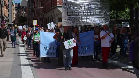 World-Economic-Forum-banner-at-environmental-protest-march,-slomo