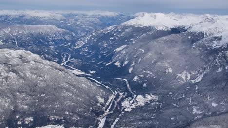 Hohe-Luftaufnahme-Eines-Schneebedeckten-Bergtals-An-Einem-Trostlosen-Wintertag