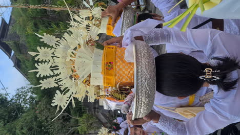 Vertical-Video,-Balinese-Women-With-Baskets-on-Head-Walking-in-Front-of-Hindu-Temple