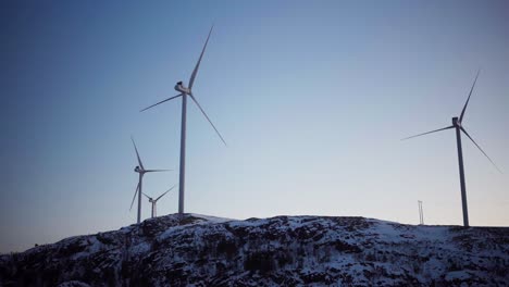 The-View-of-Wind-Turbines-Situated-Atop-Snow-capped-Mountains-in-Bessaker,-Trondelag-County,-Norway---Wide-Shot