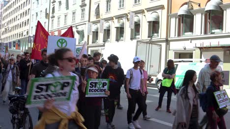 Protesters-march-with-signs-at-climate-rally-in-Stockholm,-handheld