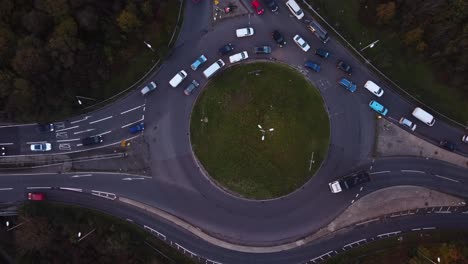 Luftaufnahme-Von-Oben-über-Einer-Kreuzung-Aus-Asphaltierter-Straße,-Kreuzung-Mit-Vorbeifahrenden-Autos,-Stadt,-Stau-Im-Alltag,-Urbaner-Stadtlebensstil